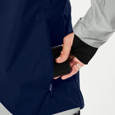 Rangement d’un smartphone dans la poche arrière zippée de la veste vélo Urban Circus