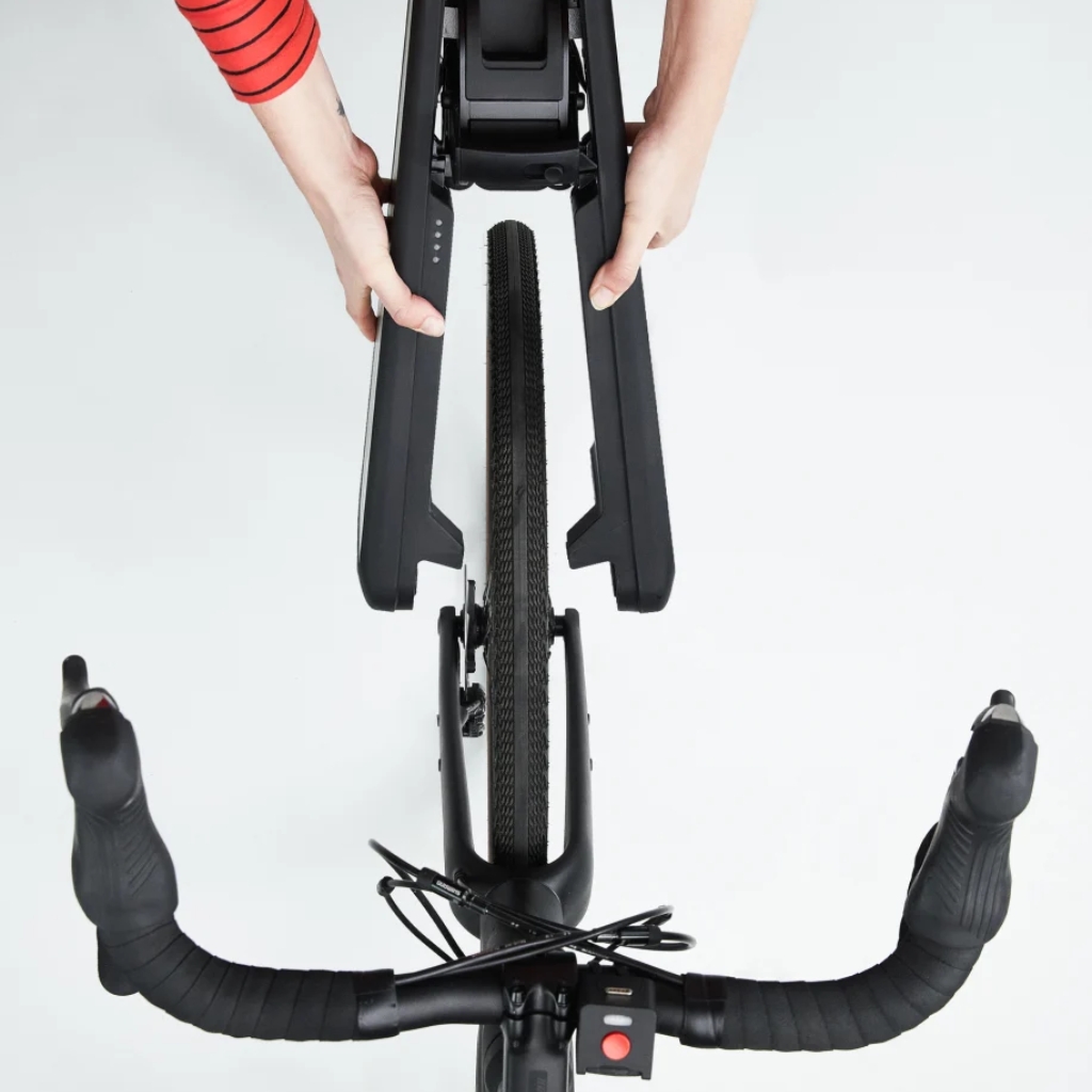 Montage d’un garde-boue de vélo noir sur la roue arrière, vu de dessus, avec guidon et mains en place.