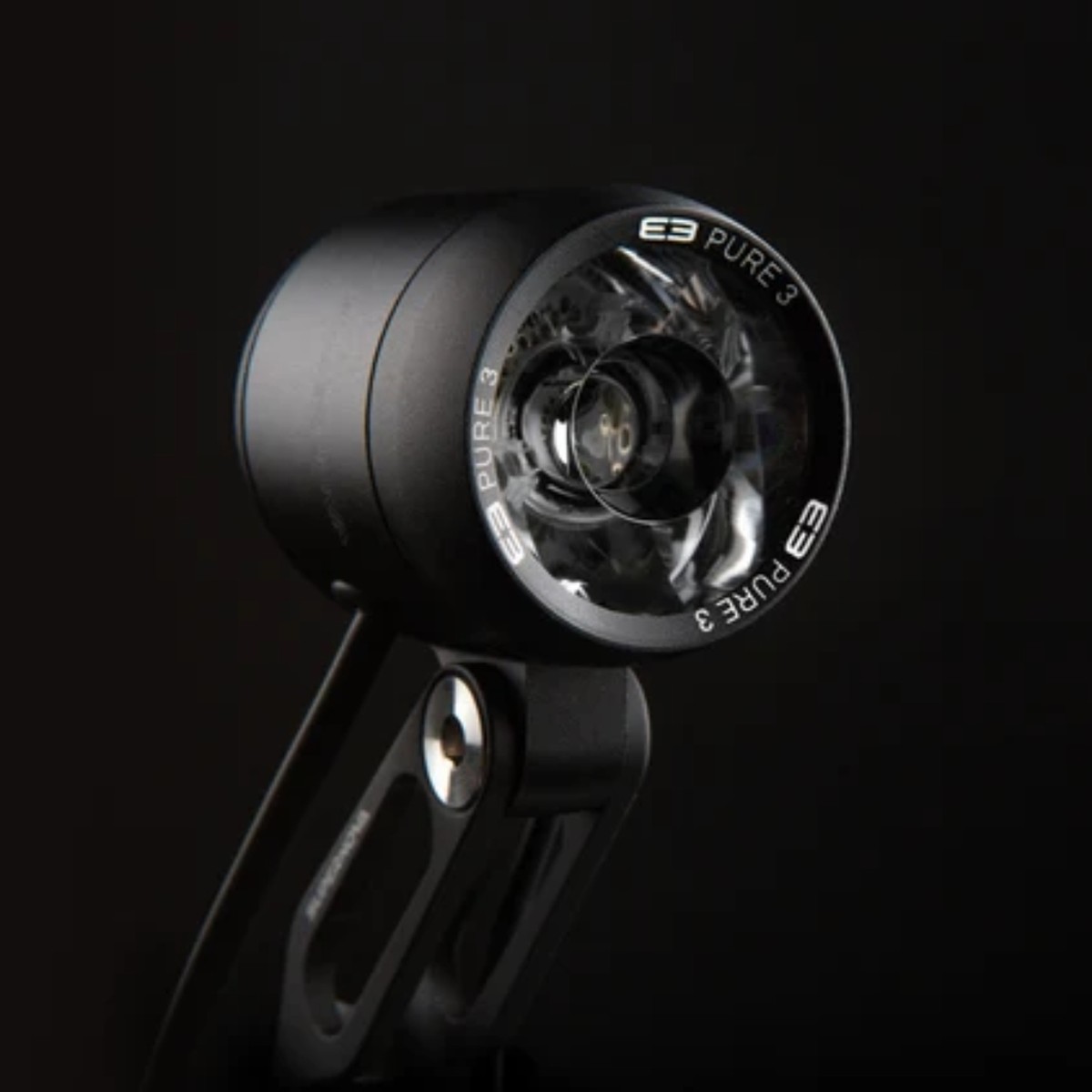 Éclairage vélo noir à LED ronde, avec support de fixation et optique marquée E3 Pure 3 sur fond noir.