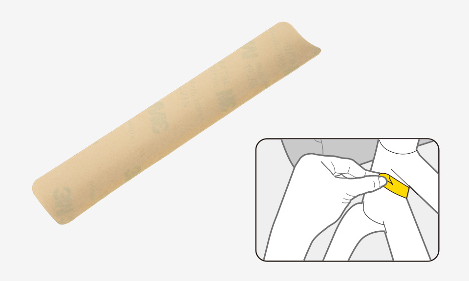 Adhésif de protection allongé beige pour cadre de vélo, avec schéma montrant sa pose à la main sur le tube.