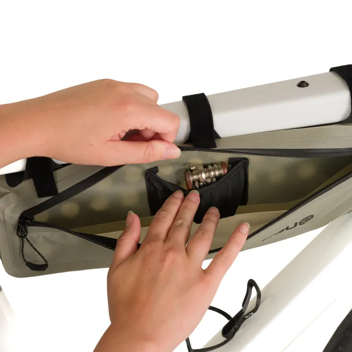 Sacoche de vélo tube frame lightweight Agu avec poche centrale ouverte, mains rangeant un antivol et petite poche filet intérieure